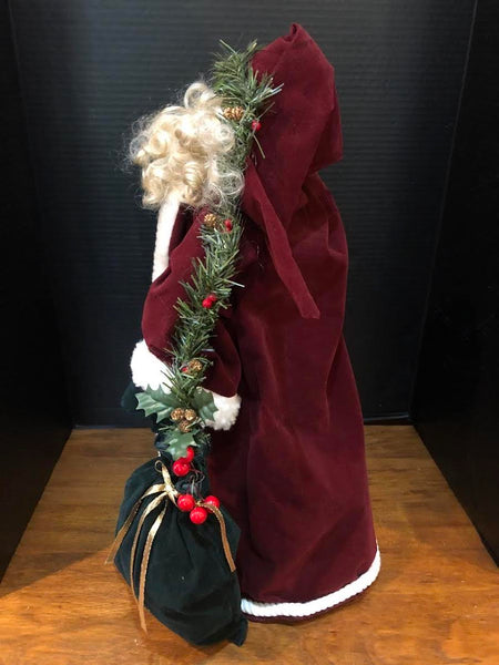 23" SANTA FIGURE IN LONG WINE COAT HOLDING WREATH AND BAG