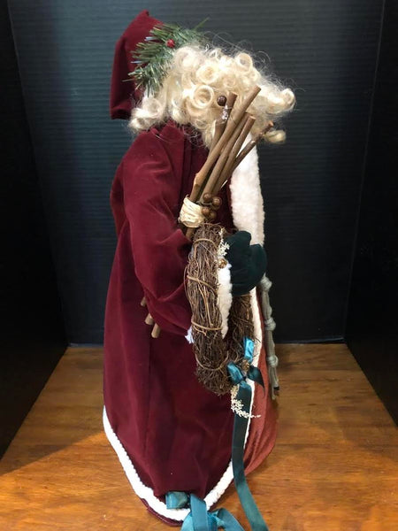 23" SANTA FIGURE IN LONG WINE COAT HOLDING WREATH AND BAG